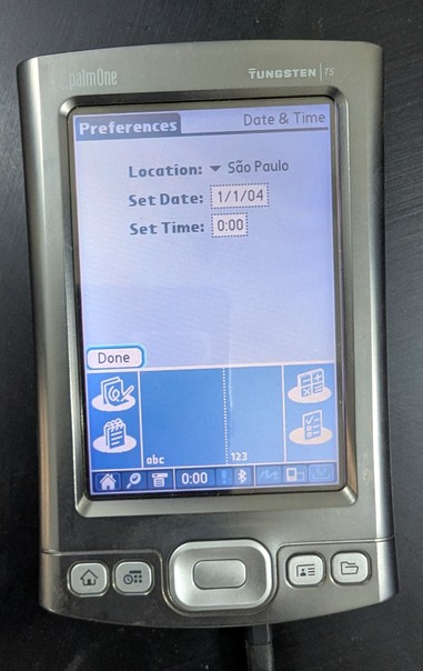A Palm Tunsgsten PDA from about 20 years back. It is plugged in to power and has switched on.