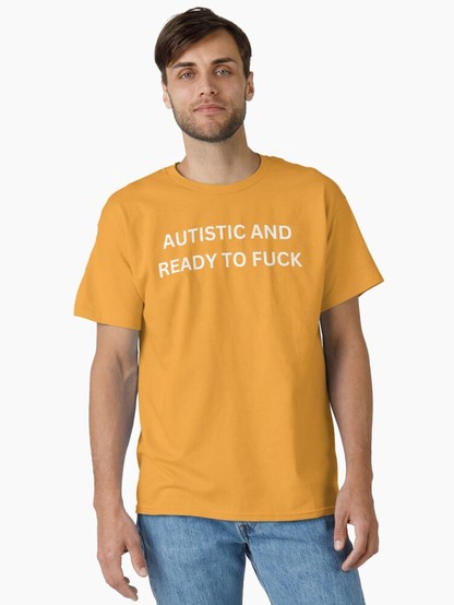 Man wearing a mustard-yellow T-shirt with bold white text "Autistic and ready to f***," paired with blue jeans. Neutral expression, minimal background.