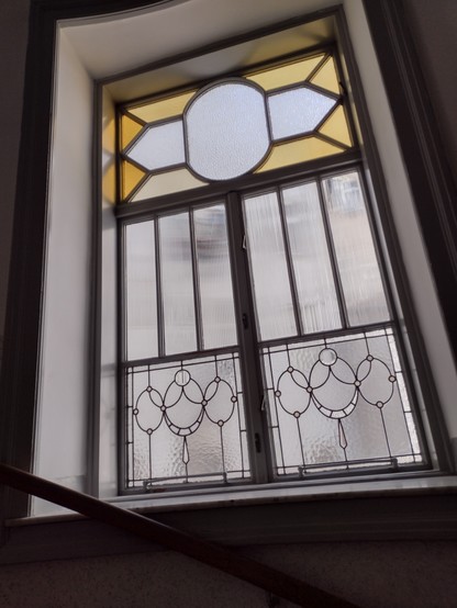 Fenster in einem Treppenhaus mit Bleiglas-Stegen, einige Teile sind sogar färbig. Das Muster würde ich als Art-Deko einschätzen.