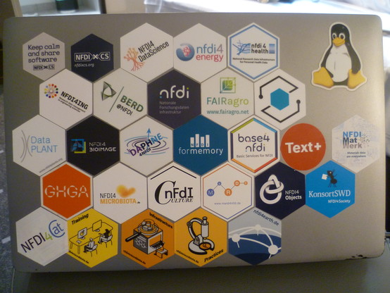A laptop with stickers on it.