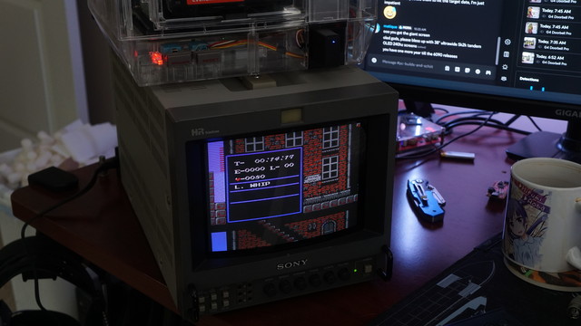 The Sony PVM-9044Q television showing the starting level from Castlevania 2 along with the pause screen.  On top of the PVM is an NES in a clear shell.