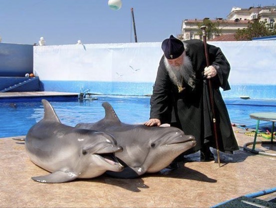 orthodox priest blessing dolphins