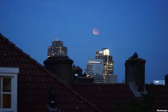 Maansverduistering boven de Rembrandttoren en de Breitnertoren in Amsterdam