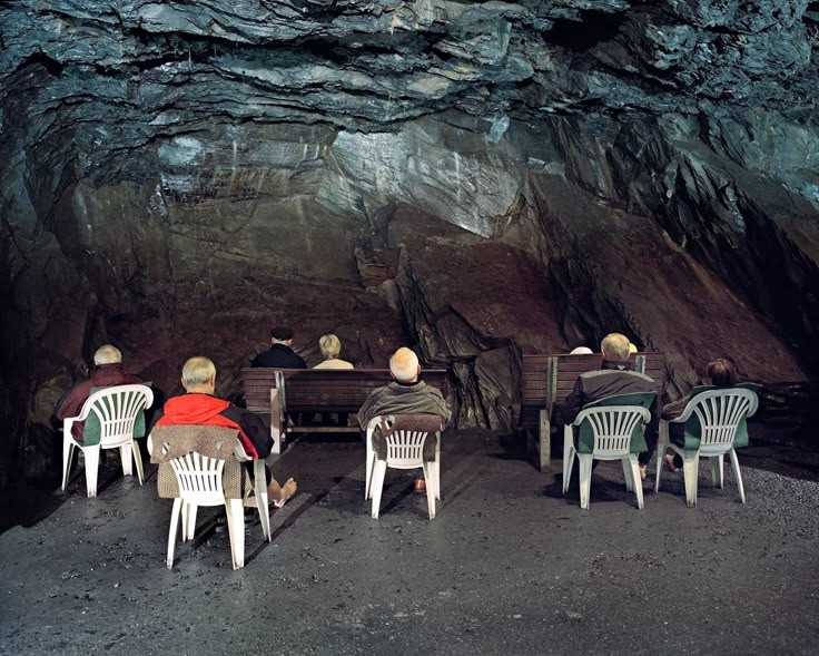 elderly people sitting in plastic chairs in the cave