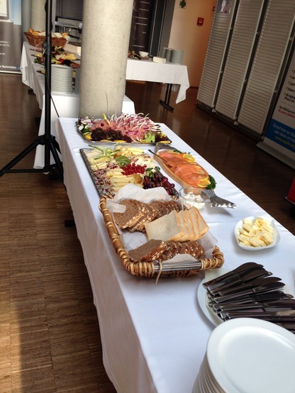 Breakfast Buffet: a long table showing Plates with different kinds of bread rolls and different toppings