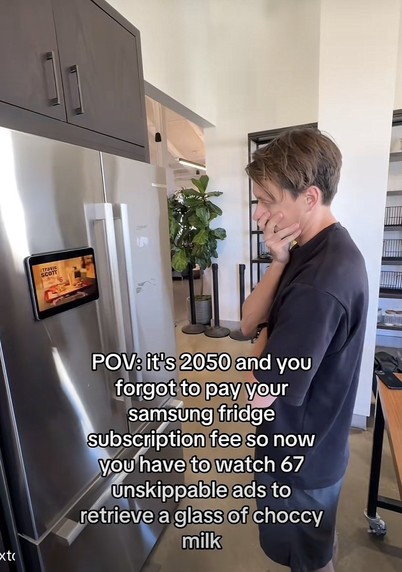 A man with hand on his face looking at his fridge with a screen displaying ads.
POV: it's 2050 and you forgot to pay your Samsung fridge subscription fee so now you have to watch 67 unskipable ads to retrieve a glass to choccy milk