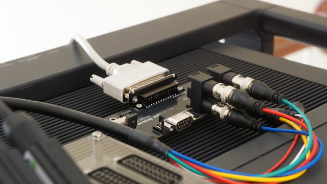 The CMPTR breakout board with RGB and sync signals connected in the front.  The DB25 cable is connected to the back of the board sitting on top of the TV.