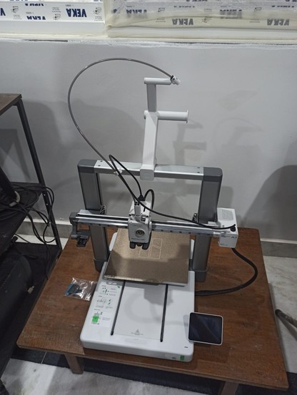 A 3D printer from Bambu on a wooden table.