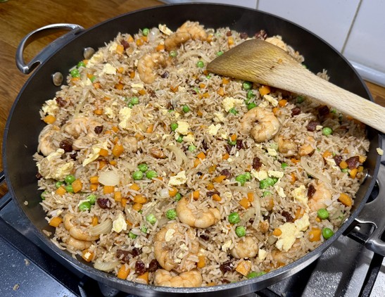 Yángzhōu Chǎofàn is fried rice with onions, carrots, peas, shrimps, eggs, and Lap Cheong sausages. Here shown still in its bigass pan