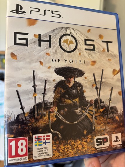 The cover of Ghost of Yotei for PlayStation 5. Next to a big PEGI 18 label is an even bigger one mentioning Scandinavian subtitle support. 