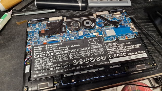 The back of an ASUS Zenbook 14 UX480. The back is taken off revealing the motherboard and the battery.