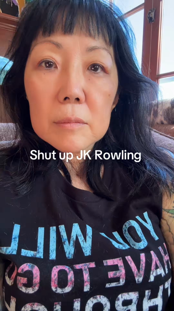 "A woman wearing a black shirt with text on it in transgender colors passionately delivers a rant against JK Rowling. She says, 'Shut up, JK Rowling, shut up! You're a joke, that's why your name is JK. Cause you are a joke. Your anti-trans rhetoric makes me sick. You are despicable. I hope that when you face menopause, you have to take a lot of gender-affirming care as I do. And when you're taking these hormones, they make your pubes grow out so thick and hard it's like a steel wool. And if any…