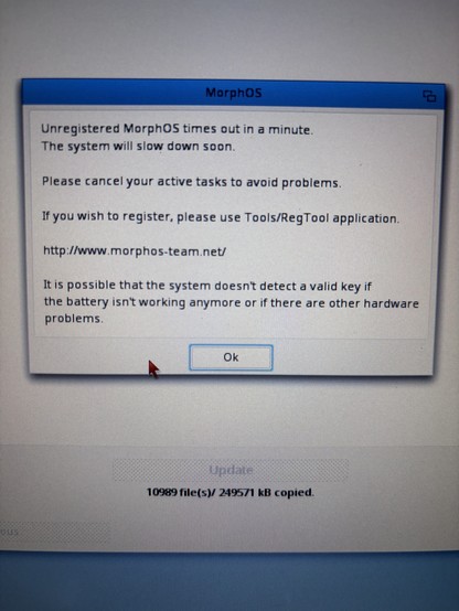 A computer screen displays a warning message from MorphOS, indicating that the unregistered system will timeout in a minute, potentially slowing down. It advises cancelling active tasks and includes a link for registration.