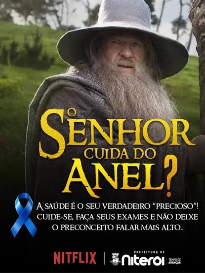 Uma imagem de propaganda com um tema de saúde. A imagem apresenta um close-up de Gandalf, de o Senhor dos Anéis, olhando para o lado. Uma fita azul está visível no canto inferior esquerdo. Acima do rosto, em letras grandes e douradas, está escrito “O SENHOR CUIDA DO ANEL?”, com a mesma fonte que normalmente é usada no título do file "O senhor dos anéis", com o óbvio objetivo de ficar parecido. Em letras menores, abaixo do rosto, está escrito 'A SAÚDE É O SEU VERDADEIRO "PRECIOSO"! CUIDE-SE, FAÇ…