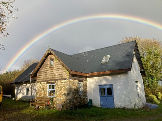 A traditional Irish cottage with an arc of diffracted sunlight over it
