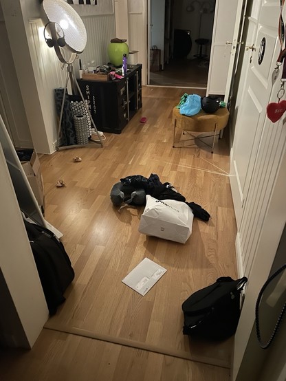 En bild på en hall med massor av saker på golvet i en oreda