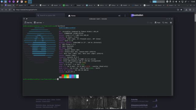 A dark themed Linux desktop with a web browser open to a Mastodon page and a Konsole window in front displaying fastfetch system information for a secureblue Fedora Atomic setup including ASCII art on the left and hardware and software details on the right.