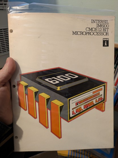INTERSIL IM6100 CMOS 12 BIT MICROPROCESSOR handbook with a drawing of a PDP-8 front panel bashed on to the front of a DIP IC