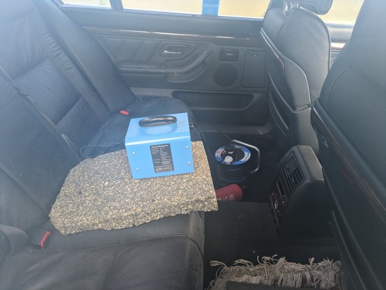 An ozone generator perched in the middle of the plush buffalo leather backseat of a long-wheelbase luxury car