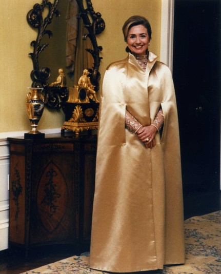Hillary Clinton from the Epstein files release wearing a long silk cloak with a lot of structure. Evil empire vibes.