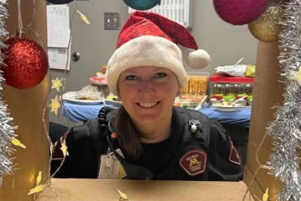 A picture of Andrea Merrell wearing a Santa hat in uniform at a work holiday party.