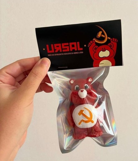 Uma mão segura um item embalado, composto por uma cartão preta e uma bolsa de plástico transparente dentro do qual há um ursinho carinhoso em cuja barriga está a foice e o martelo do comunismo.. O cartão exibe "URSAL" em letras vermelhas em grande tamanho, com "UNIÃO DAS REPÚBLICAS SOCIALISTAS DA AMÉRICA LATINA" em texto branco menor abaixo.

Fornecido por @altbot, gerado localmente e de forma privada usando Qwen3-Vl:30b e depois editado fortemente pelo autor do toot.

🌱 Energia utilizada: 0.12…