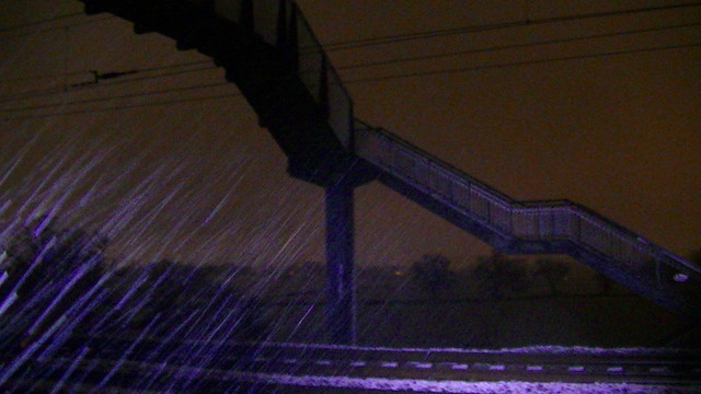 snowing from halfway up a footbridge at night