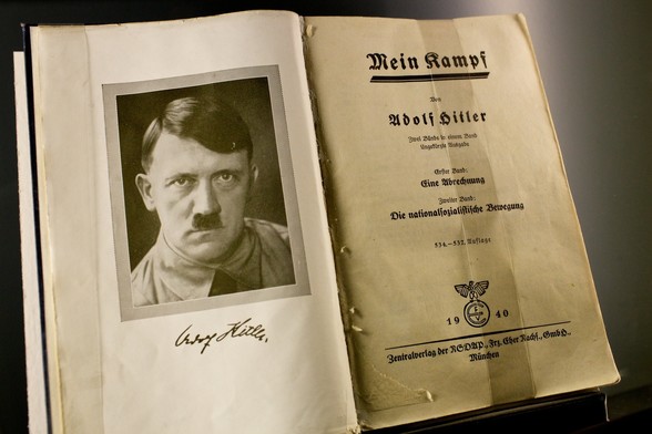 An open, worn copy of the German book Mein Kampf, showing a black-and-white portrait of the author on the left page and the title page with publication details dated 1940 on the right.