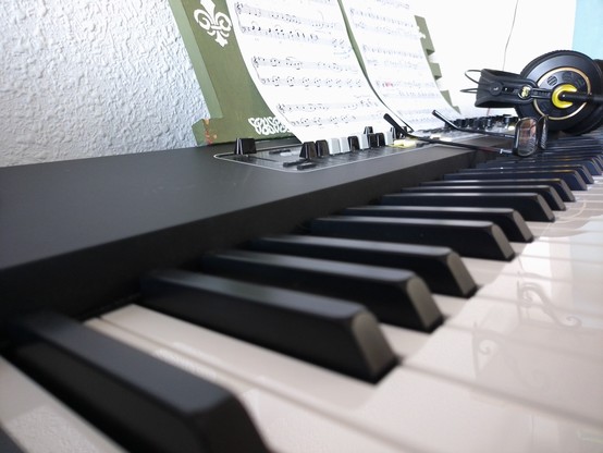 foto de un piano eléctrico. Sobre él hay unas gafas para mi presbicia, unos auriculares para no dar la turra a los vecinos y una partitura de las Danzas Polovsianas de Alexander Borodin.