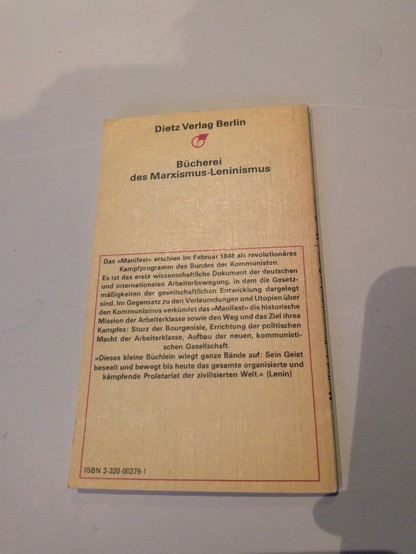 Back cover of the same worn paperback, published by Dietz Verlag Berlin as part of the “Bücherei des Marxismus-Leninismus,” with a German summary of the Communist Manifesto, a quote attributed to Lenin, and an ISBN at the bottom.