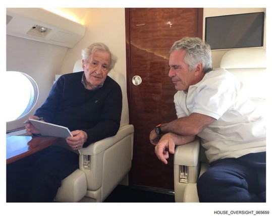 Two elderly men sit facing each other in plush leather seats inside a private jet cabin. One holds a document and looks down at it while the other leans in, listening. A small table, oval window, and wood-paneled door are visible, giving the setting a quiet, intimate feel.