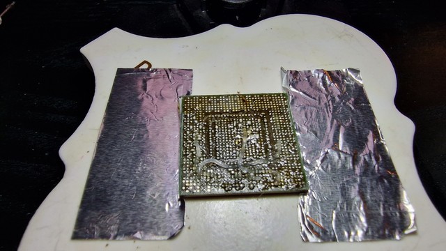 The core of the gpu, fixed on a ceramic plate using aluminum foil. The top rows are cleaned off.