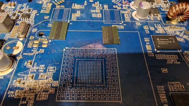 A Nvidia 9500GT, with the core and two VRAM chips taken out, sitting next to them. On the VRAM solder pads there are no ripped ones.