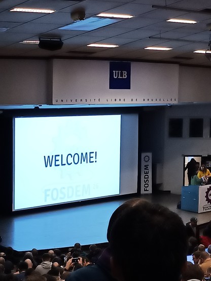 the fosdem welcome room with welcome shown on the projector
