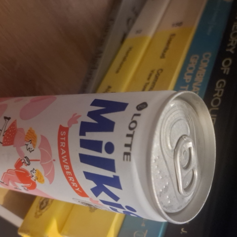 Na frente de uma pilha de livros de matemática (todos de assuntos relacionados à álgebra, como por exemplo o "Commutative Algebra" do Eisenbud) vemos uma lata de uma bebida coreana chamada "Milkis". Vemos que ela é fabricada pela Lotte e há um rótulo em inglês que parece indicar ser sabor morango.