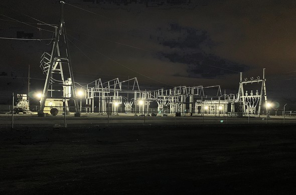 industrial electrical area at night lots of thin metal pole