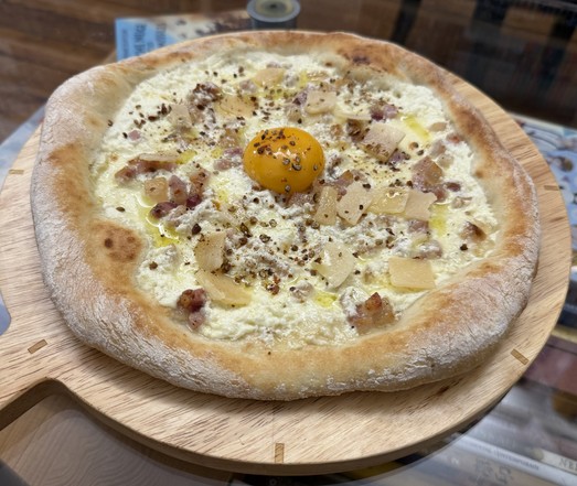 A carbonara pizza! The base is essentially ricotta and cream, then mozzarella and guanciale, and after cooking an egg yolk, Parmesan flakes and a shitload of red Kampot pepper. A drizzle of truffle oil just for fun.