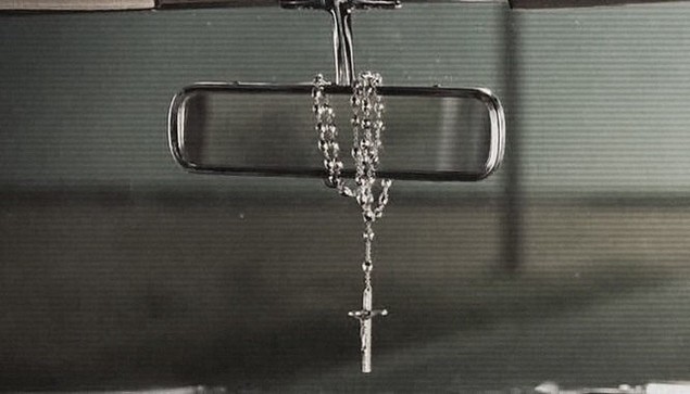 cross necklace wrapped round hanging down from car mirror