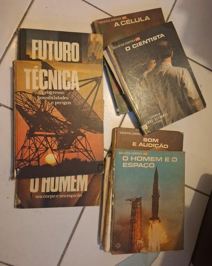 Vários livros da antiga "biblioteca científica life": 1) o homem e o espaço; 2) som e audição; 3) o cientista; 4) a célula. Também vemos mais três livros parecidos: "futuro", "técnica" e "o homem, seu corpo e seu espírito". Percebe-se que são livros antigos e que um deles está até com a capa solta.
