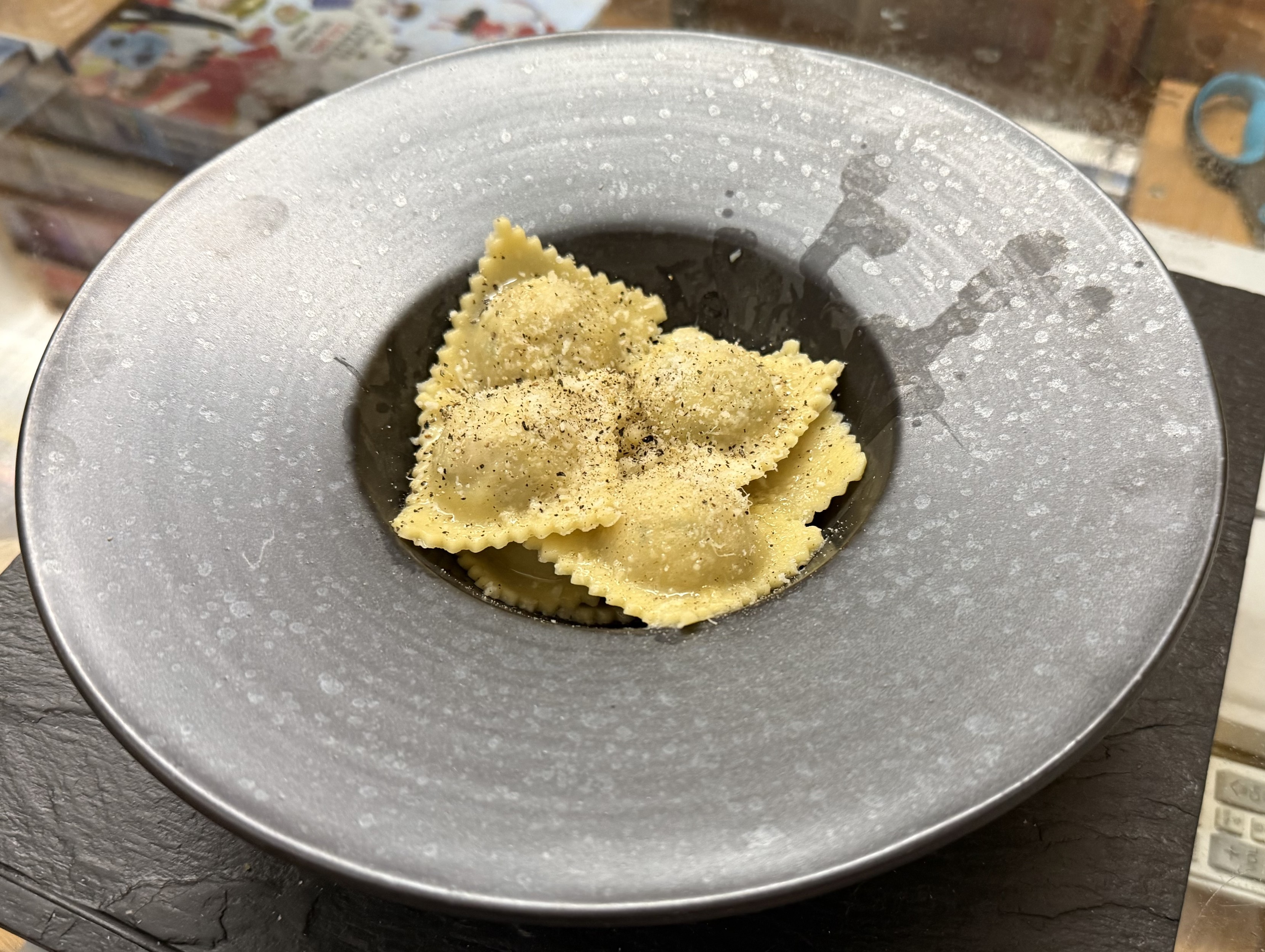 Eight home-made ricotta & nuts ravioli in one of those fancy plates that look like a little bowl surrounded by an actual plate