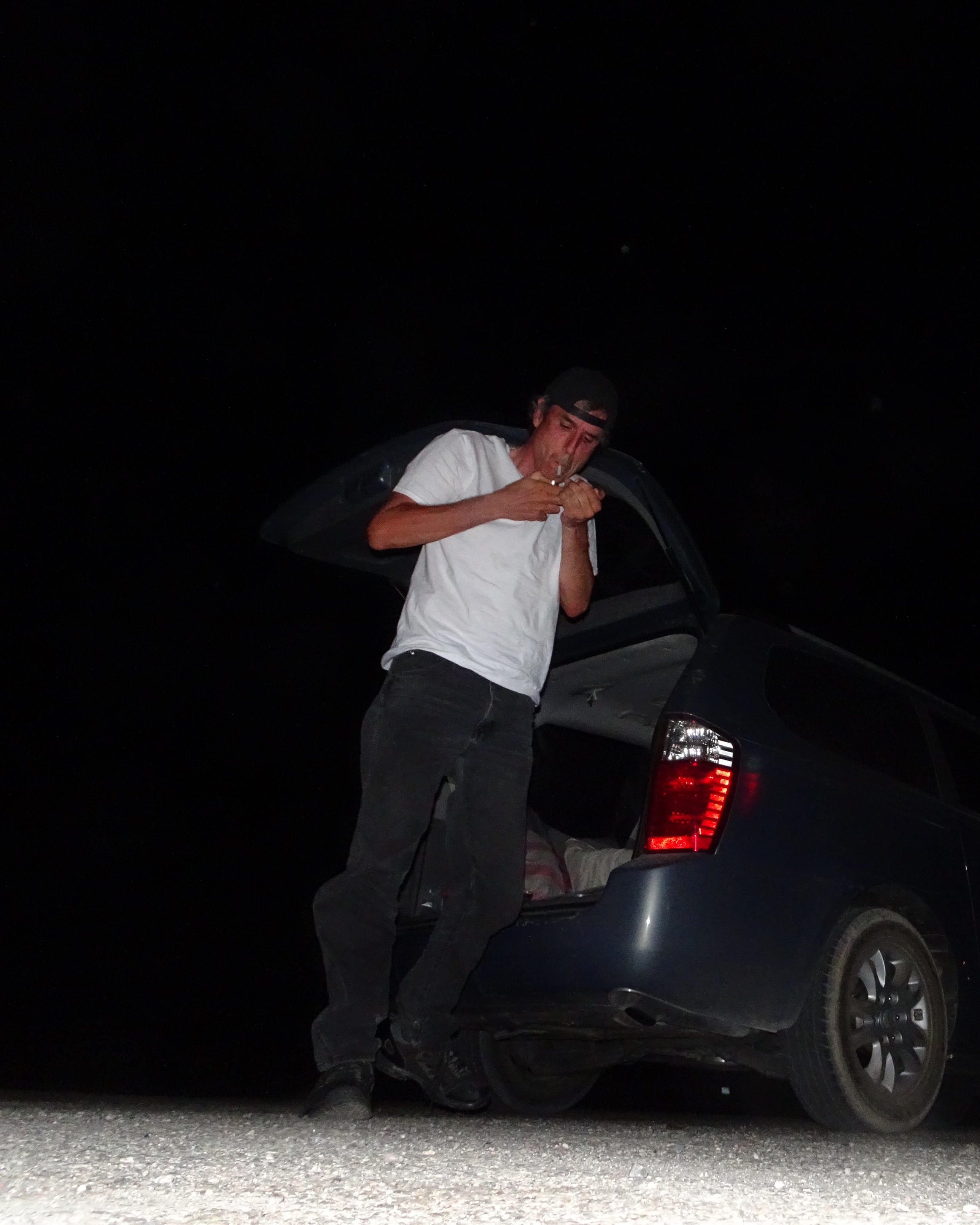 terry davis smoking with a backwards hat at night