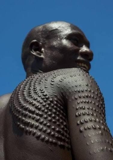 The permanent markings on the skin are a reminder of the struggle this person went through. Many cultures have practiced ritual scarification for that reason. It is a deeply human instinct to react with respect and veneration to such things.