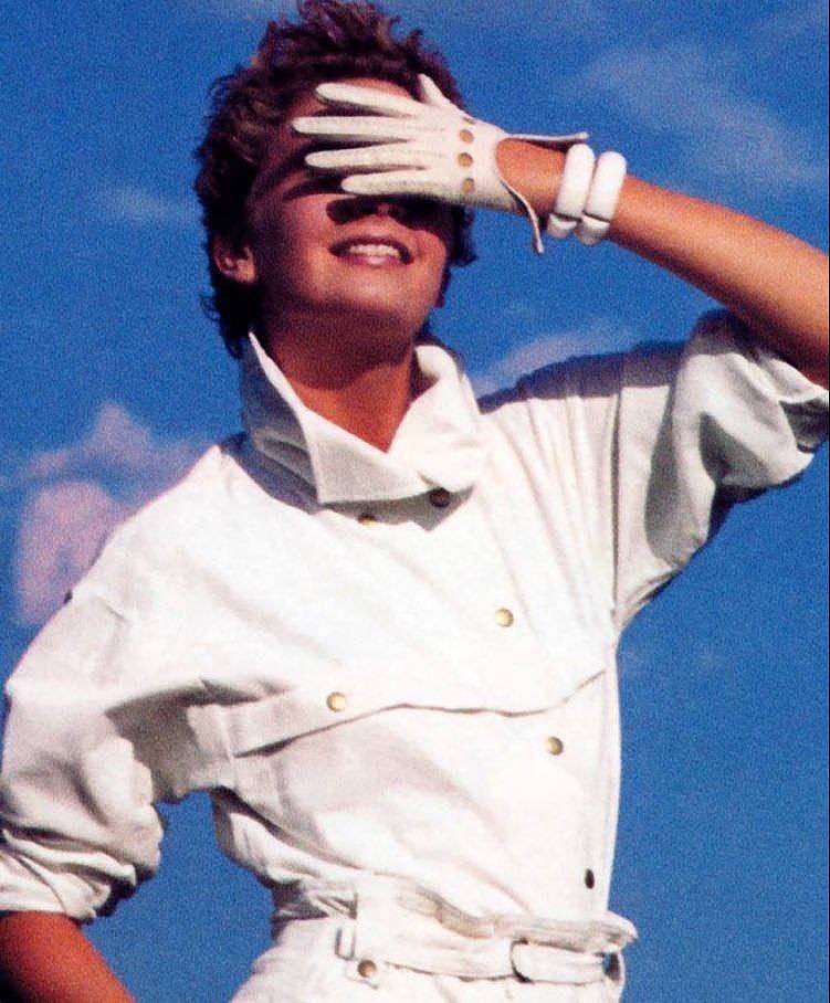 white glove blocks out blue sky. woman in outfit for flight