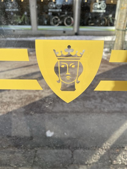 Ett fotografi av glaset i en busskur med stockholm stads vapen tryckt på glaset.