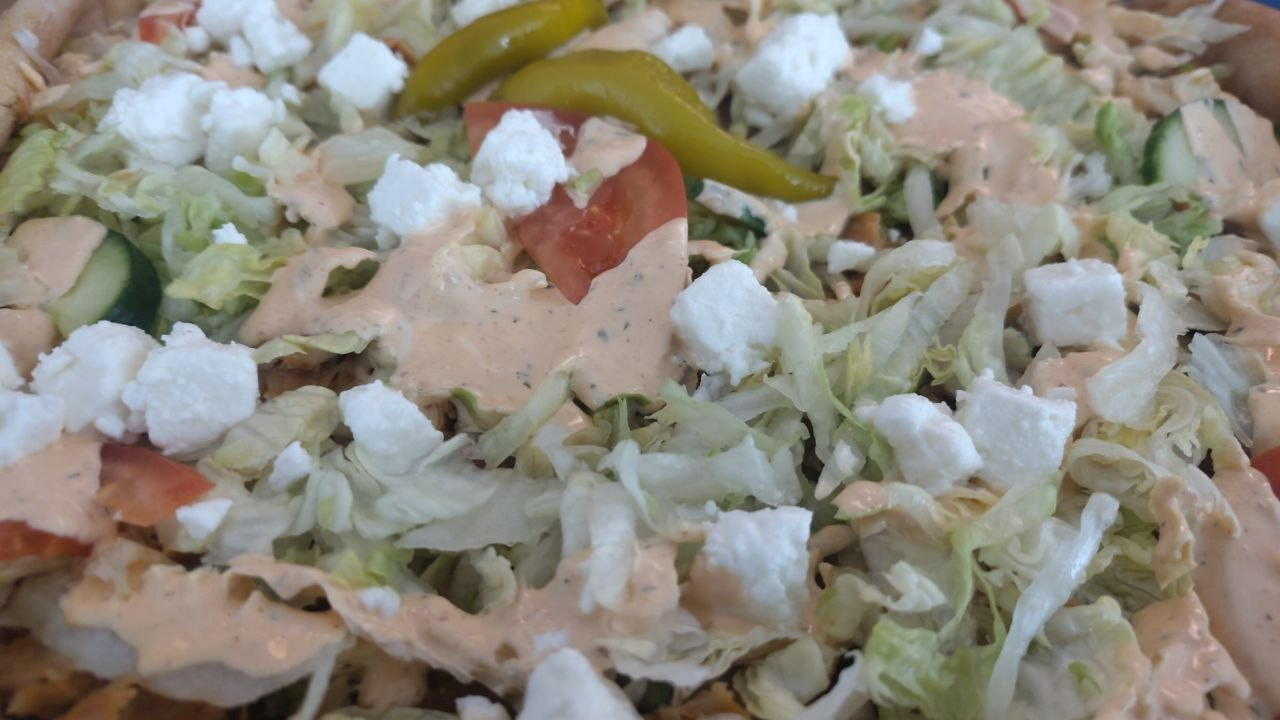 närbild på en kebabpizza med sallad på