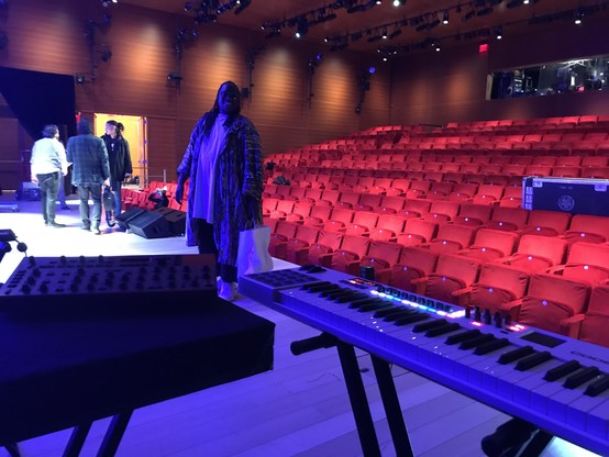 Man in front of audience seats; keyboard