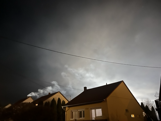 Houses in the evening in Hungarian village; backlight from a lit-up playfield.