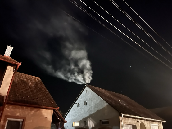 Houses in the evening in Hungarian village; backlight from a lit-up playfield.