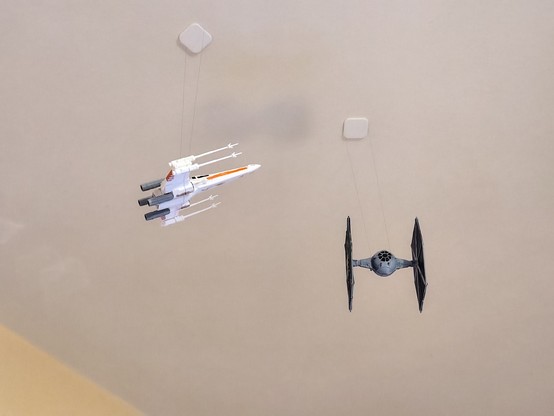 X-Wing Fighter engaging with a Tie Fighter. 3Dprinted models hung up from the ceiling with nylon wire,