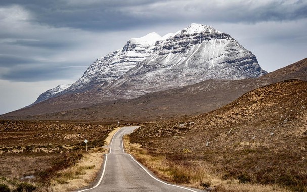 gigantic snow capped mountain down the road and the brown landscape surrounding it. if u know who took this let me know